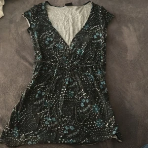 Blus från Gina  - Snygg blus från Gina tricot med blåa detaljer- perfekt för utomlands och den sitter fint i midjan då man kan knyta den