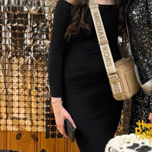 Svart off shoulder klänning från new yorker  - Svart off shoulder-klänning från New Yorker Elegant och figurnära maxiklänning i ribbat, stretchigt tyg. Off shoulder-design som ger en stilren och feminin look. Perfekt för både fest och middagar, enkel att klä upp eller ner med accessoarer.