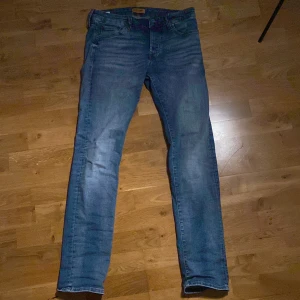 Blå slim fit jeans från Jack & Jones - Säljer ett par blå jeans från Jack & Jones, modell Slim/Glenn. Jeansen har en smal passform, klassisk femficksdesign och är tillverkade i denim. Perfekta för dig som gillar en modern och stilren look. Strl 30/32, nypris ca 900