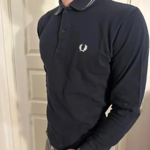 Mörkblå långärmad pikétröja från Fred Perry - Snygg mötkblå långärmad pikétröja från Fred Perry