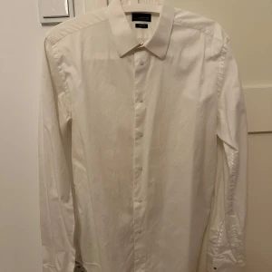 Vit skjorta från Zara Man - Säljer en klassisk vit skjorta från Zara. Skjortan har en stilren design med långa ärmar och knappar framtill. Perfekt för en stilren look.