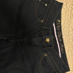 Svarta jeans från Esprit - Snygga svarta jeans från Esprit med klassisk femficksdesign och kontrasterande sömmar. Byxorna har en knappgylf och är perfekta för en stilren look. Passar till många olika tillfällen.