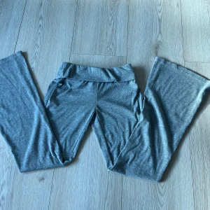 Grå ribbade byxor - Snygga grå ribbade byxor med en bekväm passform. De har en hög midja och vida ben, vilket ger en avslappnad och trendig look. Perfekta för en stilren vardagsoutfit.🩷