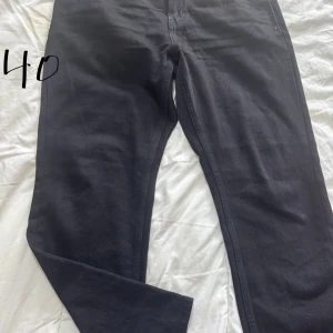 Svarta jeansbyxor - Snygga svarta jeansbyxor med klassisk femficksdesign. De har en rak passform och är perfekta för en stilren look. Passar bra till både vardag och mer uppklädda tillfällen.