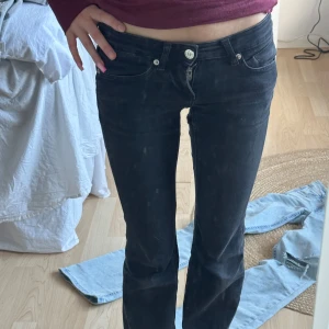 Svarta jeansbyxor - Snygga svarta jeansbyxor med låg midja och tight passform. Byxorna har klassisk femficksdesign och en dragkedja med knapp framtill. Perfekta för en stilren look.