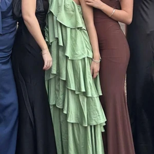 Grön volangklänning - Säljer en fantastisk grön långklänning med volanger. Klänningen har en omlott-design och är ärmlös med halterneck-stil. Perfekt för sommarens fester och baler. Nypris 4000kr💚