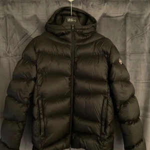 Svart pufferjacka från Colmar - Svart colmarjacka som säljes då den ej kommer användas mer. Använd i typ 2 månader och har inga skador. Jag är 188 och den passar mig. Nypris 7499kr.
