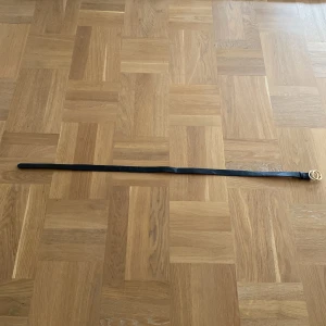 Svart och beige bälte från H&M - Snyggt bälte från H&M i svart och beige med en stilren dubbel ringformad guldfärgad spänne. Perfekt för att ge en extra touch till din outfit. Tillverkat i Kina.