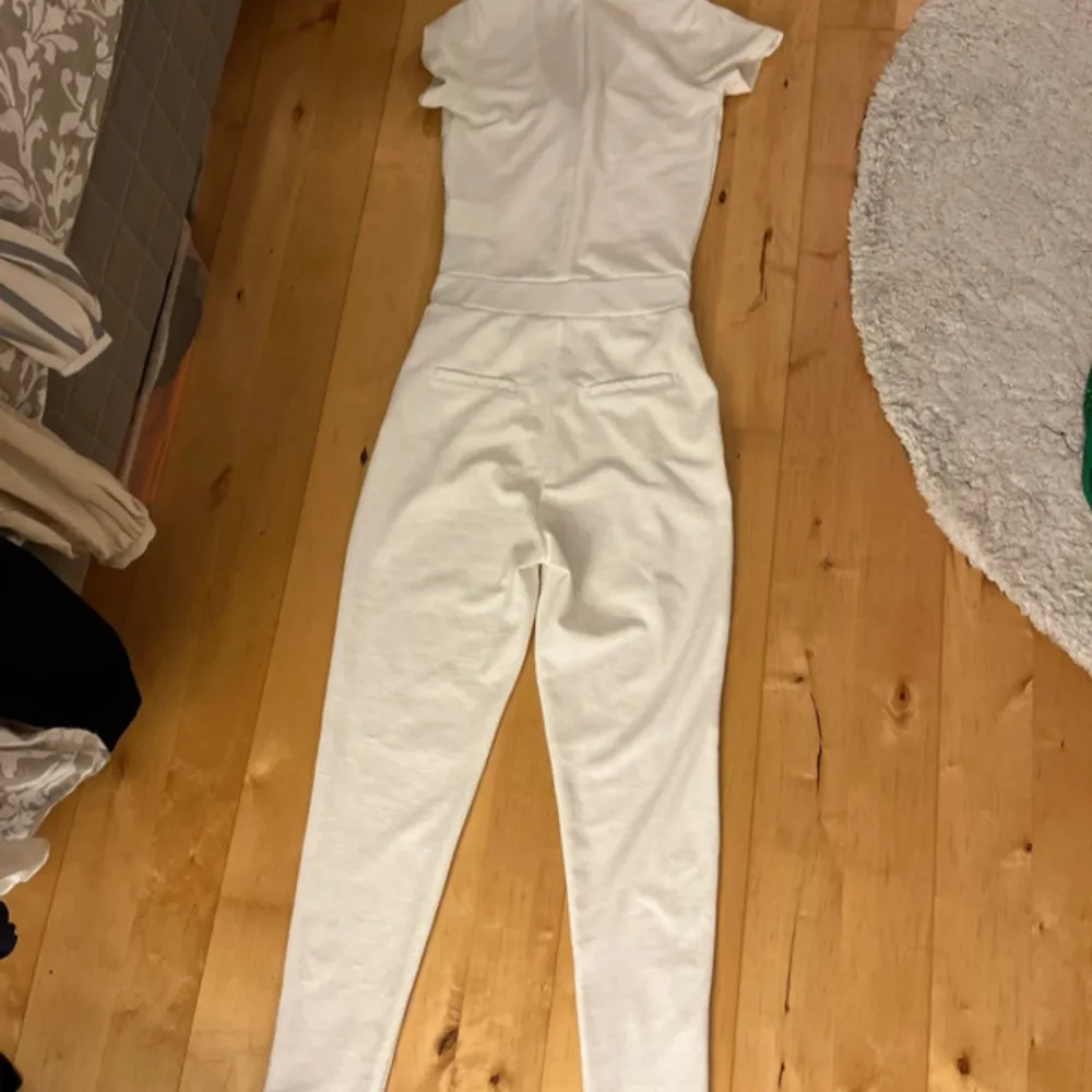 Säljer en stilren vit jumpsuit med korta ärmar och rund hals. Aldrig använd🤍. Mekot.