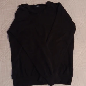 Svart tröja från MAN - Säljer en stilren svart tröja från MAN. Tröjan har en klassisk design med långa ärmar och en bekväm passform. Perfekt för att hålla stilen enkel och snygg. Har ett litet hål vid armhålan.