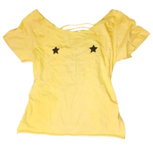 Cool topp - Säljer en gul topp med svarta stjärnor framtill och en unik öppen rygg med snörningsdetaljer. Toppen har korta ärmar och en lös passform. Perfekt för en avslappnad stil.