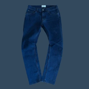 Grå jeansbyxor från Acne Studios - Säljer ett par klassiska grå jeans från Acne Studios. Byxorna har fem fickor, raka ben och normal passform. Perfekta för dig som gillar stilrena och tidlösa jeans. Stängs med dragkedja och knapp.