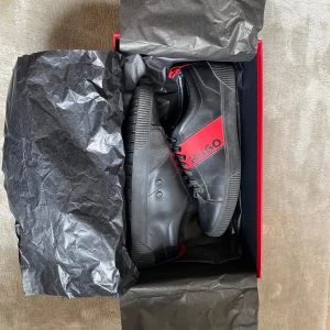 Svarta sneakers från Hugo med röda detaljer - Storlek 41 men funkar med 42-42 1/2
