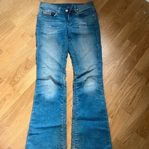 Blå bootcut jeans från Diesel - Säljer ett par blå bootcut jeans från Diesel, modell Lowleeh. Jeansen har slitna detaljer framtill och är low waist. Perfekta!