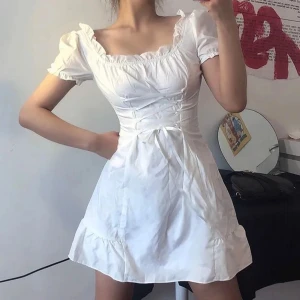 Vit kort puffärmad klänning med volang - Söt vit klänning med puffiga ärmar och korsetteffekt. Perfekt för somriga dagar, skolavslutning eller studentfirande. Nyskick.🌸