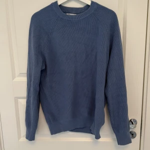 Blå stickad tröja från Zara - Säljer en blå stickad tröja från Zara med rund halsringning och långa ärmar. Tröjan har en enkel och stilren design utan mönster, perfekt för lager-på-lager under kyliga dagar.