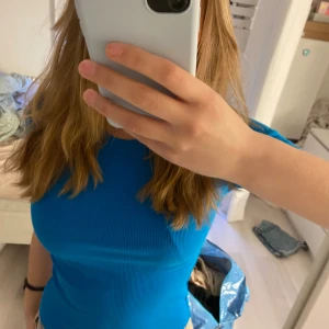 Blå ribbad t-shirt från Zara - Säljer en blå ribbad t-shirt från Zara. T-shirten har rund halsringning och korta ärmar. Enkel och stilren modell som sitter tight och är gjord i ett stretchigt material.