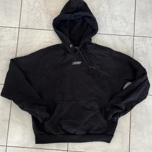 Svart hoodie från I STAY - Säljer en svart hoodie från I STAY i storlek M. Tröjan har huva med dragsko, magficka och ribbade muddar vid ärmslut och nederkant. Perfekt för en avslappnad stil.