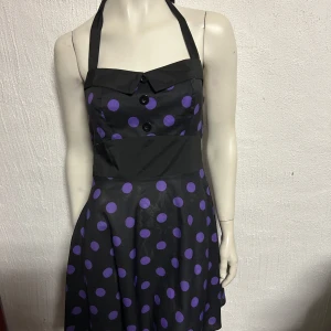 50-talsklänning helterneck stl M - Helt ny klänning med knytning bakom halsen. Material i skön polyester. Smalt resårband upptill i ryggen för att anpassa efter kroppen. Storlek M.