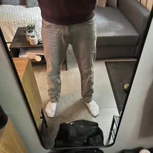 Grå jeansbyxor med raka ben - Säljer ett par grå jeansbyxor från Jack o jones med raka ben och klassisk femficksdesign. Byxorna har normal passform och midwaist. Perfekta till vardags för en avslappnad stil.