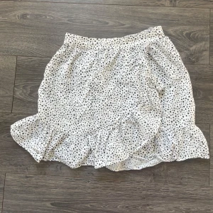 Vit prickig kjol från Vero Moda - Supersöt vit kjol från Vero Moda med svarta prickar och volang nertill! Skriv för intresse!💞