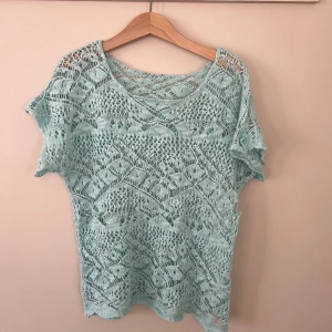 Virkad topp - Säljer en ljusblå, spetsstickad topp från Kappahl. Tröjan har några defekter skriv mer för fler bilder