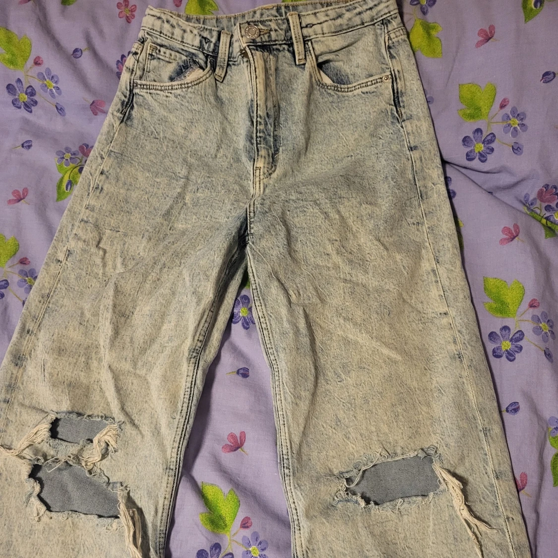 Ljusblå slitna jeans med vida ben