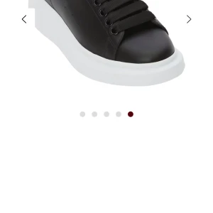 Svarta sneakers med vit plattformssula - Säljer ett par svarta Alexander mqueens sneakers med vit, hög plattformssula och svarta skosnören. Skorna har en stilren design och är tillverkade i slätt material. Perfekta för dig som gillar en modern och clean look.