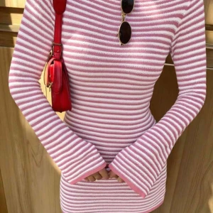 Rosa och vit randig stickad klänning  - Säljer en söt stickad klänning med rosa och vita ränder. Tröjan har lång ärm och en tight passform som framhäver figuren. Perfekt för dig som gillar färg och mönster!