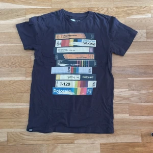 Svart t-shirt med Polaroid-tryck från Dedicated - Cool svart t-shirt från Dedicated med  tryck framtill. Gjord av 100% ekologisk och Fairtrade-certifierad bomull. 