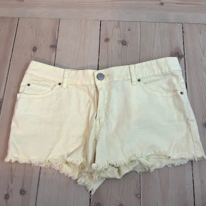 Gula jeansshorts med fransar - Snygga ljusgula jeansshorts med fransig kant nertill. Klassisk femficksmodell med knapp och dragkedja framtill. ⭐️🌟💛