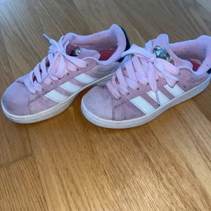 Adidas campus 00s - Adidas campus 00s i färgen ”lilac bliss”, storlek 37 1/3. Säljer då de inte passar mig längre. De är i använt skick. Som man kan se på andra bilden är de lite noppriga på insidan, men det är inget som påverkar. Undersidan av sulan är smutsig såklart men det kan man tvätta bort.