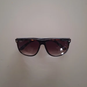 RayBan boyfriend solglasögon  - Snygga solglasögon från Ray-Ban med brunmelerad båge och mörktonade glas. Klassisk fyrkantig form som passar de flesta ansikten. Perfekt accessoar för soliga dagar.