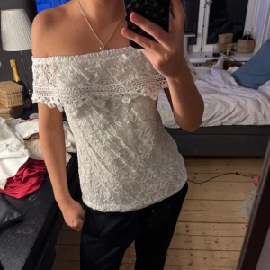 Vit offshoulder spetsblus - Säljer en vit offshoulder blus i spets med volangdetalj upptill. 