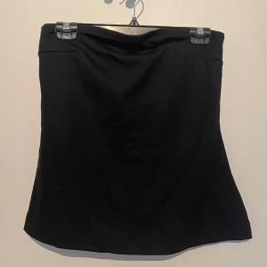Svart offshoulder/tubtopp Kappahl - svart tubtopp från Kappahl. toppen har en åtsittande passform där uppe och blir flowy längre ner. aldrig använd och kommer från ett djur och rökfritt hem 🖤
