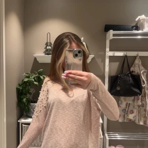 Beige/ljusrosa långärmad tröja med pärldetaljer - Säljer en beige långärmad tröja med snygga pärldetaljer på axlarna och överdelen av ärmarna. Tröjan har en mjuk och tunn känsla, perfekt för lager-på-lager. Enkel rund halsringning och relaxed fit. Knappt använd. Nypris ish 200kr. (Finns ej kvar på hemsidan). 