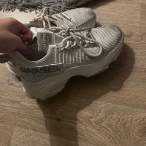 Vita sneackrs Steve madden  - Chunky sneakers i vit med stickad ovandel och grov sula. Skorna har snörning och detaljer i syntetmaterial samt en tydlig logga på sidan. Perfekta för en trendig och sportig look.
