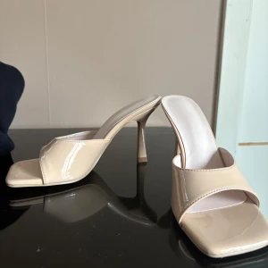 Beige klackade - Säljer ett par stilrena beige sandaler med hög klack och öppen tå. Aldrig använt dom, för höga för mig. 10 cm hög klack