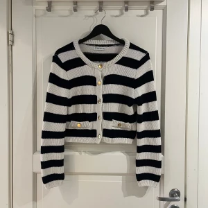 Randig kofta från Stradivarius - Söt marinblå och svart randig stickad kofta från Stradivarius. Koftan är croppad med guldknappar💙Perfekt till sommaren