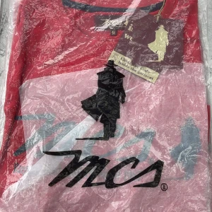 Röd och rosa långärmad tröja från MCS - Säljer en snygg långärmad tröja från MCS i rött och rosa med stor svart logga och siluett framtill. Tröjan har rund halsringning och är perfekt för dig som gillar streetwear med en unik touch.