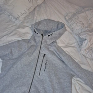 Grå sail racing zip  - Säljer en grå sail racing zip hoodie i storlek medium. Använd några gånger. Nypris 1500, mitt pris 500