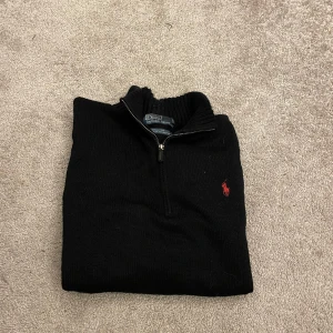 Svart stickad Ralph Lauren half zip.  - En otroligt skön stickad half zip från Ralph Lauren med det röda märket av Polo på bröstet. Grym kvalitet med storlek M på tröjan. 