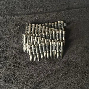 Patronbälte i silver  - Säljer ett svart bälte med stora, silvriga metallspetsar i rad längs hela bältet. Bältet har en tuff och edgy design som sticker ut och passar perfekt för dig som vill ha en unik accessoar.