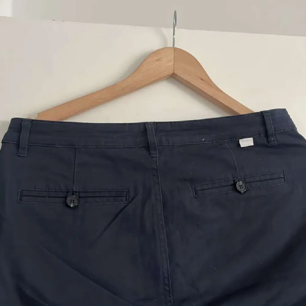 Säljer ett par mörkblå chinos från Mouli i storlek w31. Byxorna har normal passform, knäppning med knapp och dragkedja samt två bakfickor med knappar. Perfekta för en stilren och avslappnad look.. Farkut & Housut.