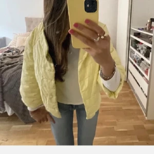 Gul quiltad pufferjacka - Säljer en ljusgul quiltad pufferjacka med loose passform. Jackan har trekvartsärmar och är lätt vadderad, perfekt för vår eller kyliga sommarkvällar. Superfin att slänga över en t-shirt och jeans.🌼🌼