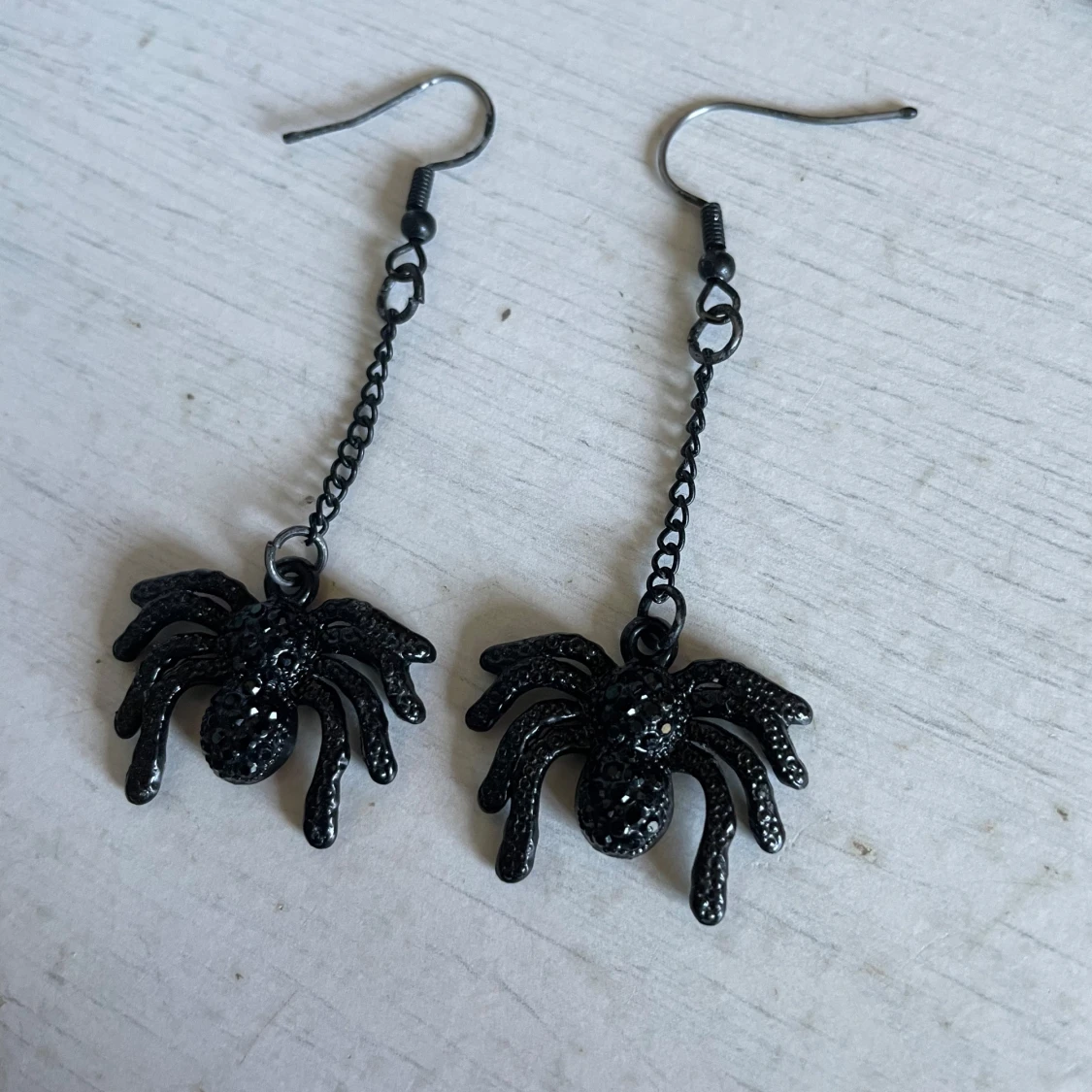 Svarta örhängen med spindelmotiv