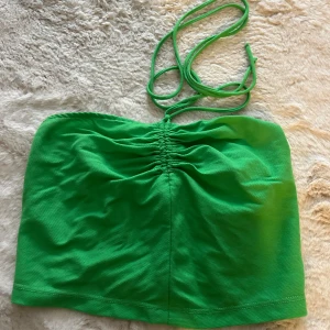 Grön bandeau tubtopp med snörning - Bandeau tubtopp med smala knytband i nacken och rynkdetalj framtill. Storlek M, men liten i storleken. Som en S enligt mig🫶🏻