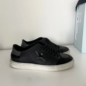 Svarta sneakers från Axel Arigato - Svarta sneakers från Axel Arigato med broderad fågel på sidan och vit platt sula. Perfekta för dig som gillar stilrena och trendiga skor med en unik touch. KÖPTA FÖR 2699kr! ⭐️Tvättas helt innan leverans!
