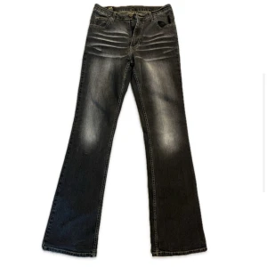 Svarta Lee jeans bootcut - Säljer ett par svarta jeans från Lee med snyggt slitna detaljer och bootcut. Jeansen är i storlek W31 L34 och har lite stretch.