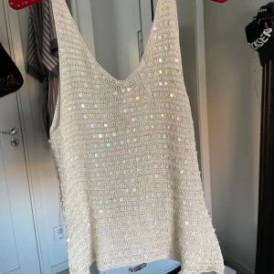 Beige virkad paljettopp - Säljer en vit linnetopp med glittrande paljetter över hela. Perfekt till sommaren☀️står ingen storlek men skulle säga att den är lite lös så mellan s-m